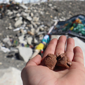 Hand holding capers pantry freeze dried chocolate ice cream against a mountainous background with visible prayer flags
