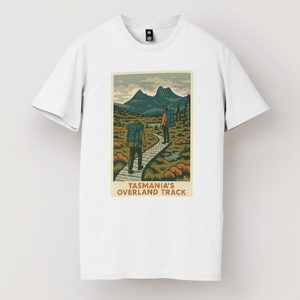 A white t-shirt featuring a graphic print of the Overland Track in Tasmania with a mountainous landscape and a hiker on the trail.