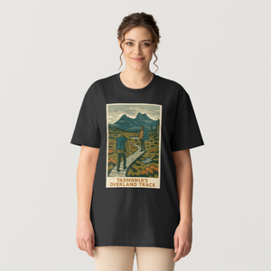 Person wearing a black t-shirt with a graphic design of the Overland Track Tasmania Trail Tee Shirt on a plain background